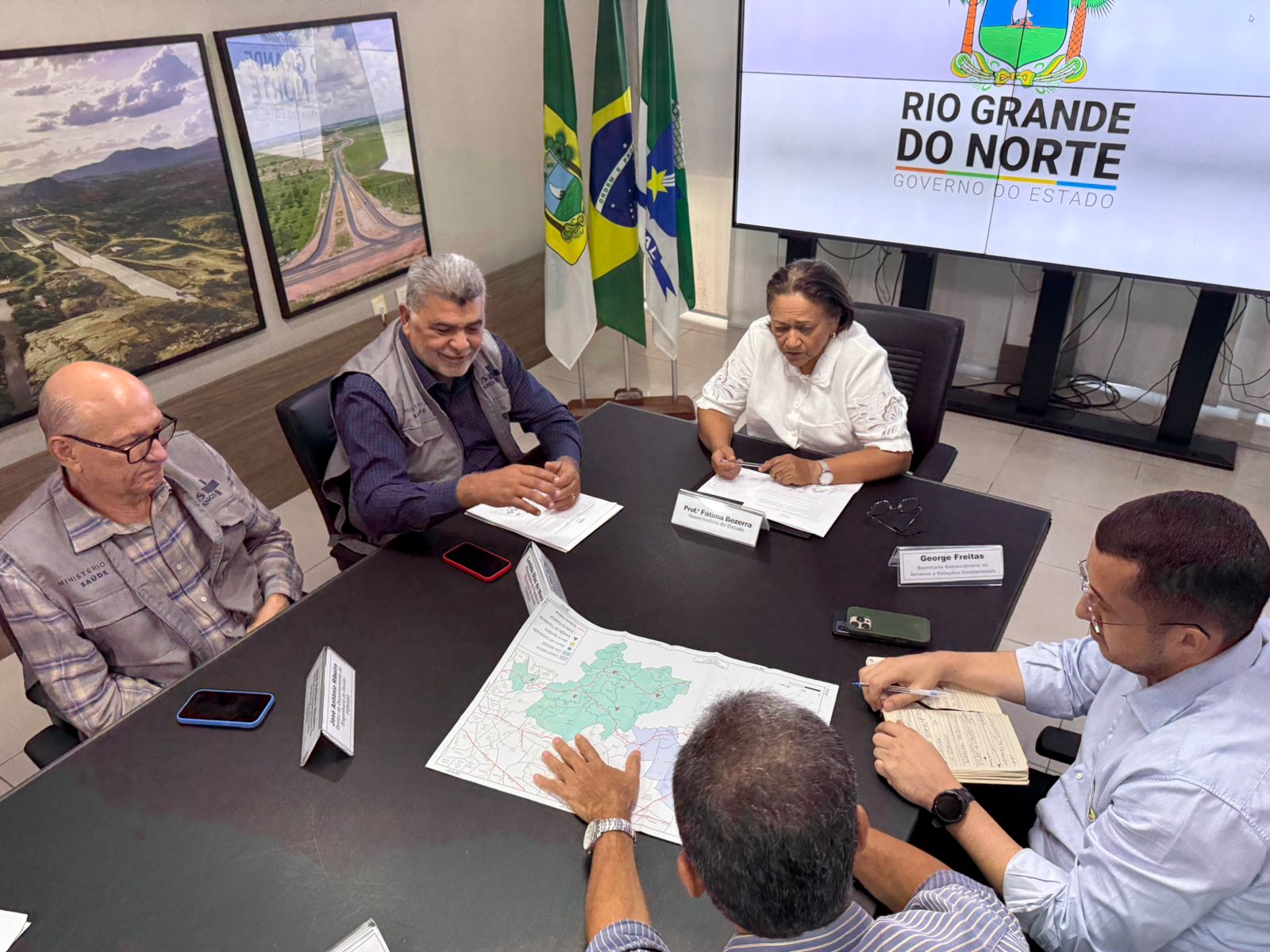 Autoridades em reunião analisam mapa do Rio Grande do Norte sobre projetos estaduais.