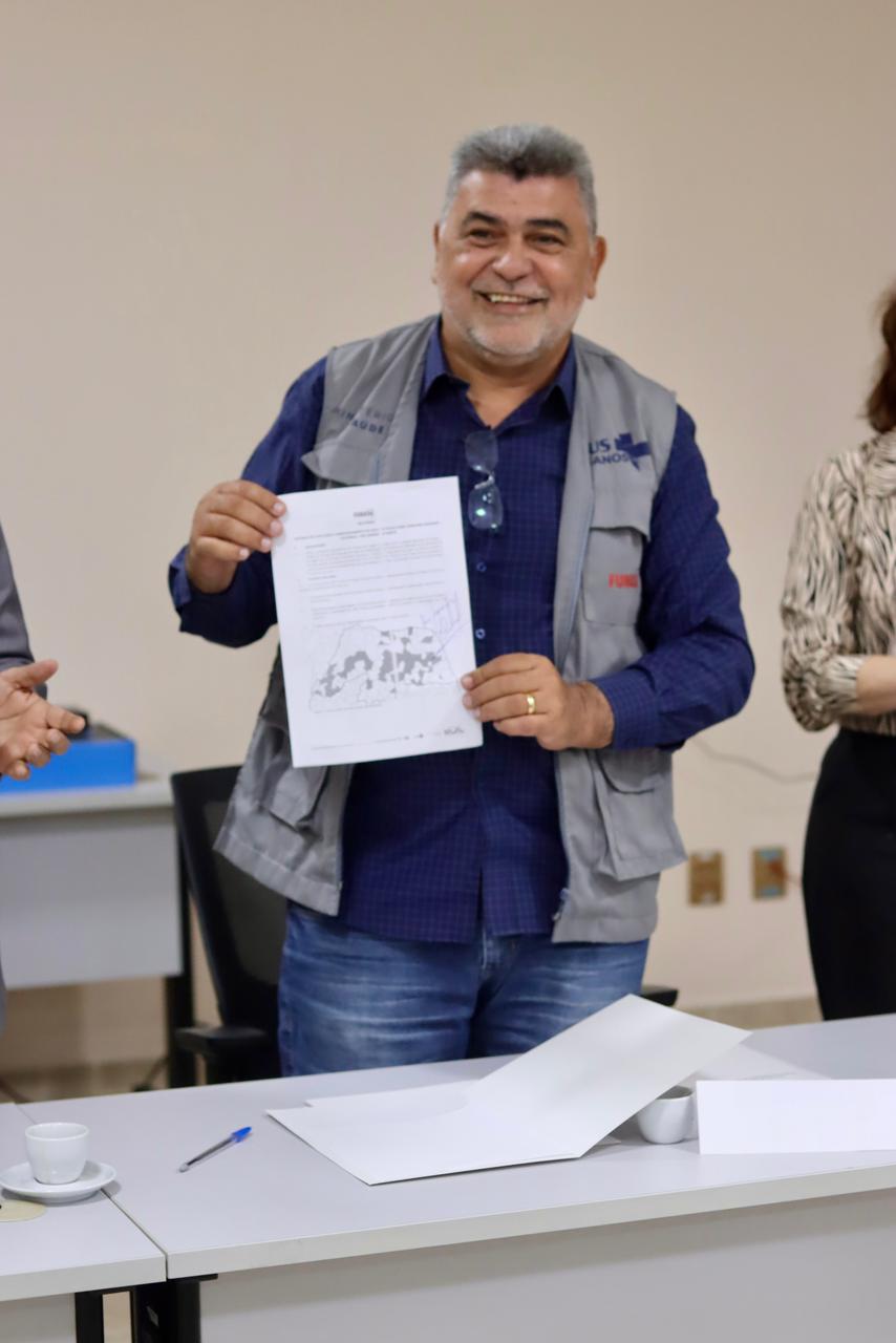 Lenildo Morais sorri e exibe documento oficial com o mapa do Rio Grande do Norte.