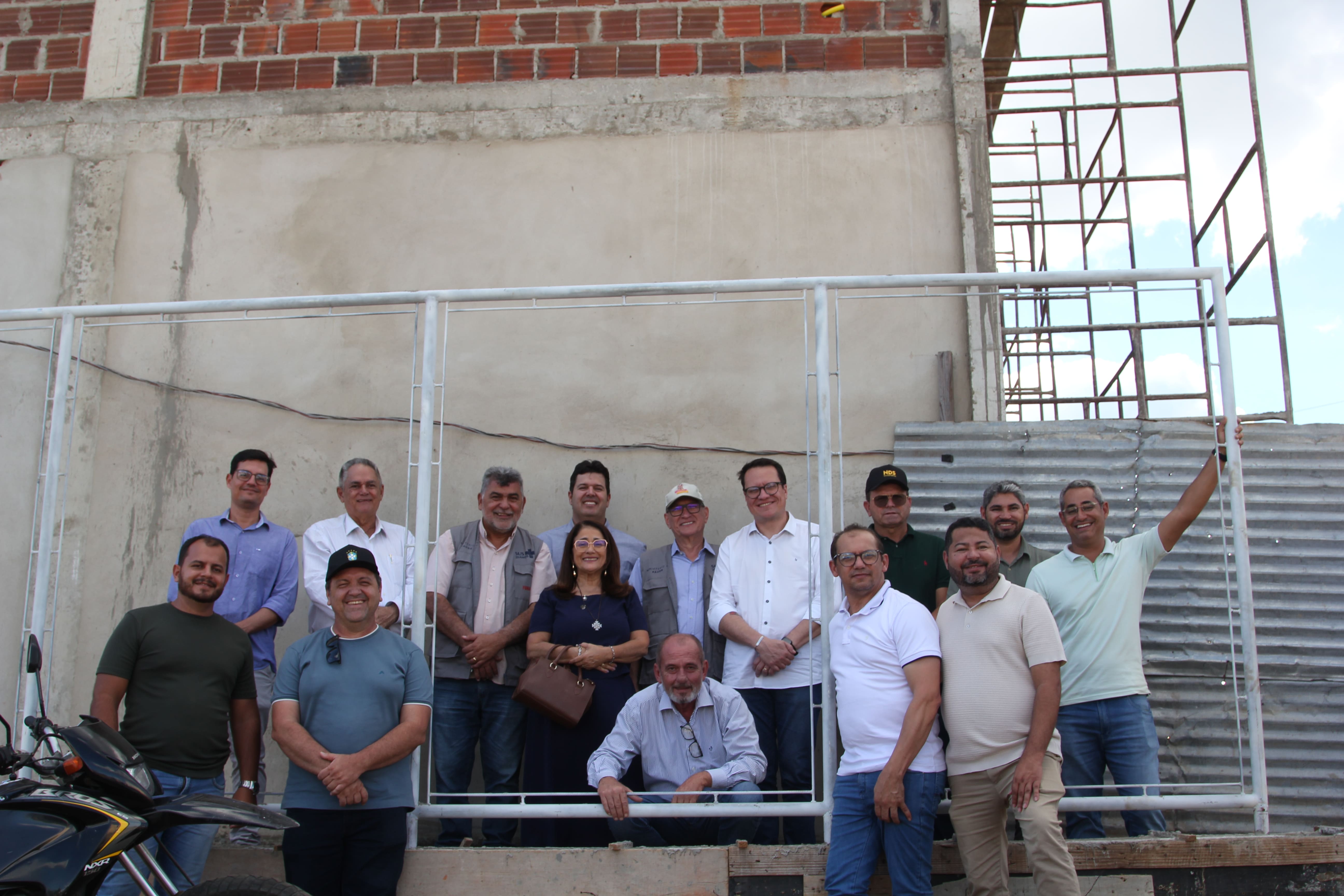 Grupo de pessoas posa em frente à fachada em obras do novo laboratório de qualidade da água.