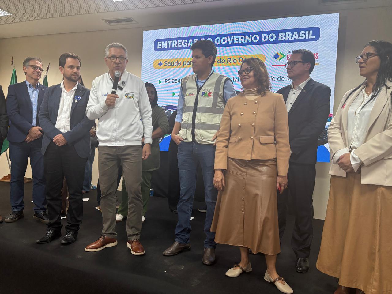 Ministro Alexandre Padilha fala ao microfone ao lado de outras autoridades sobre o palco.