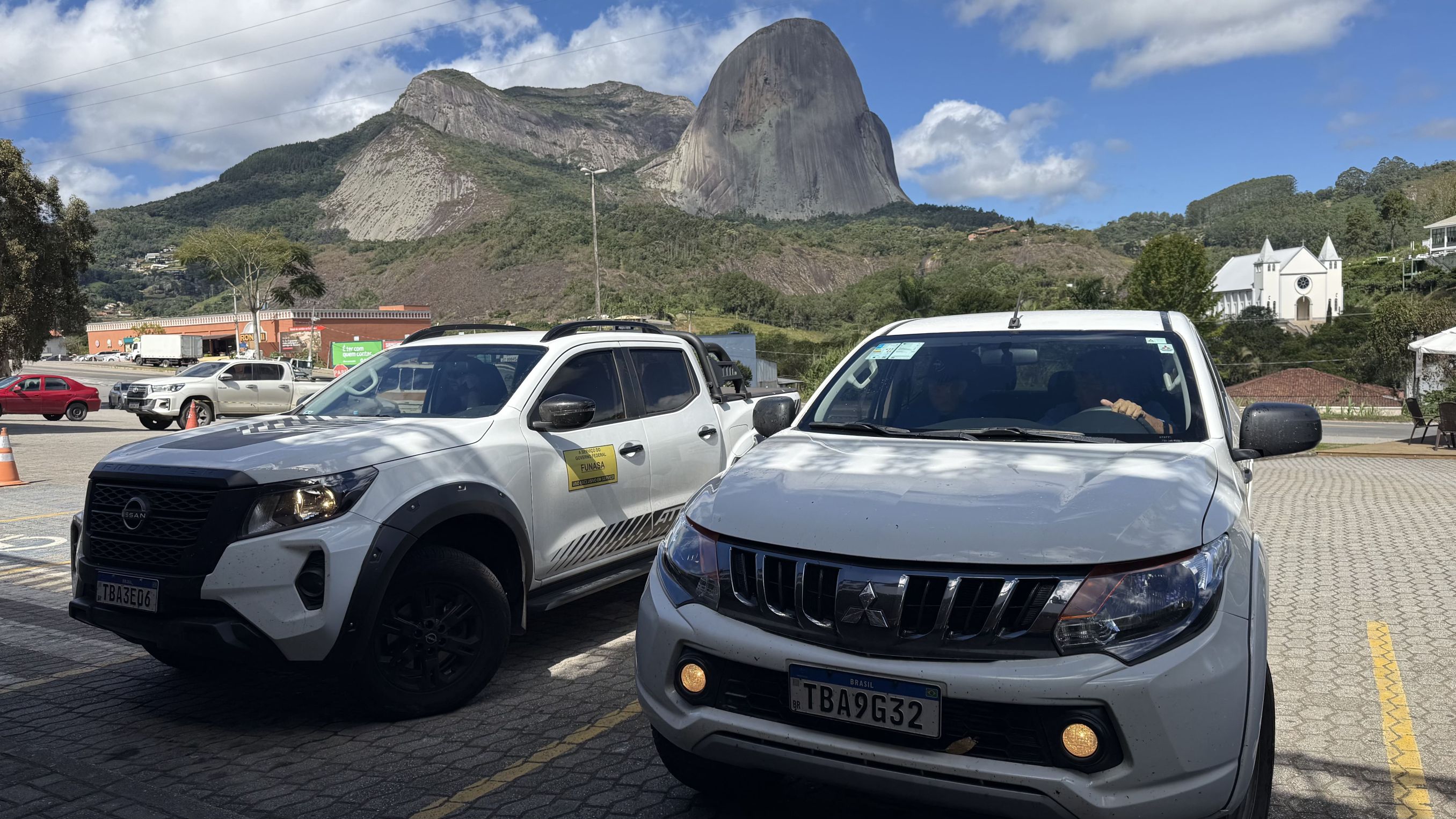 Dois carros brancos compactos, veículos de apoio da Funasa.