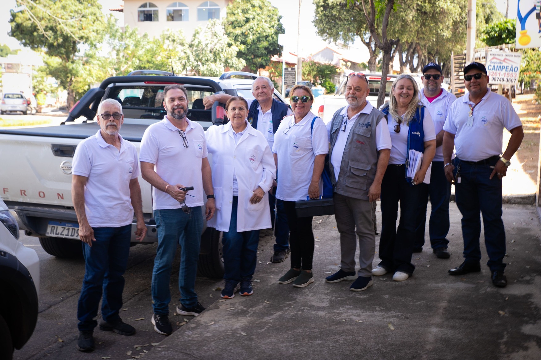 Grupo de técnicos da Funasa posa para foto ao lado de uma caminhonete branca.