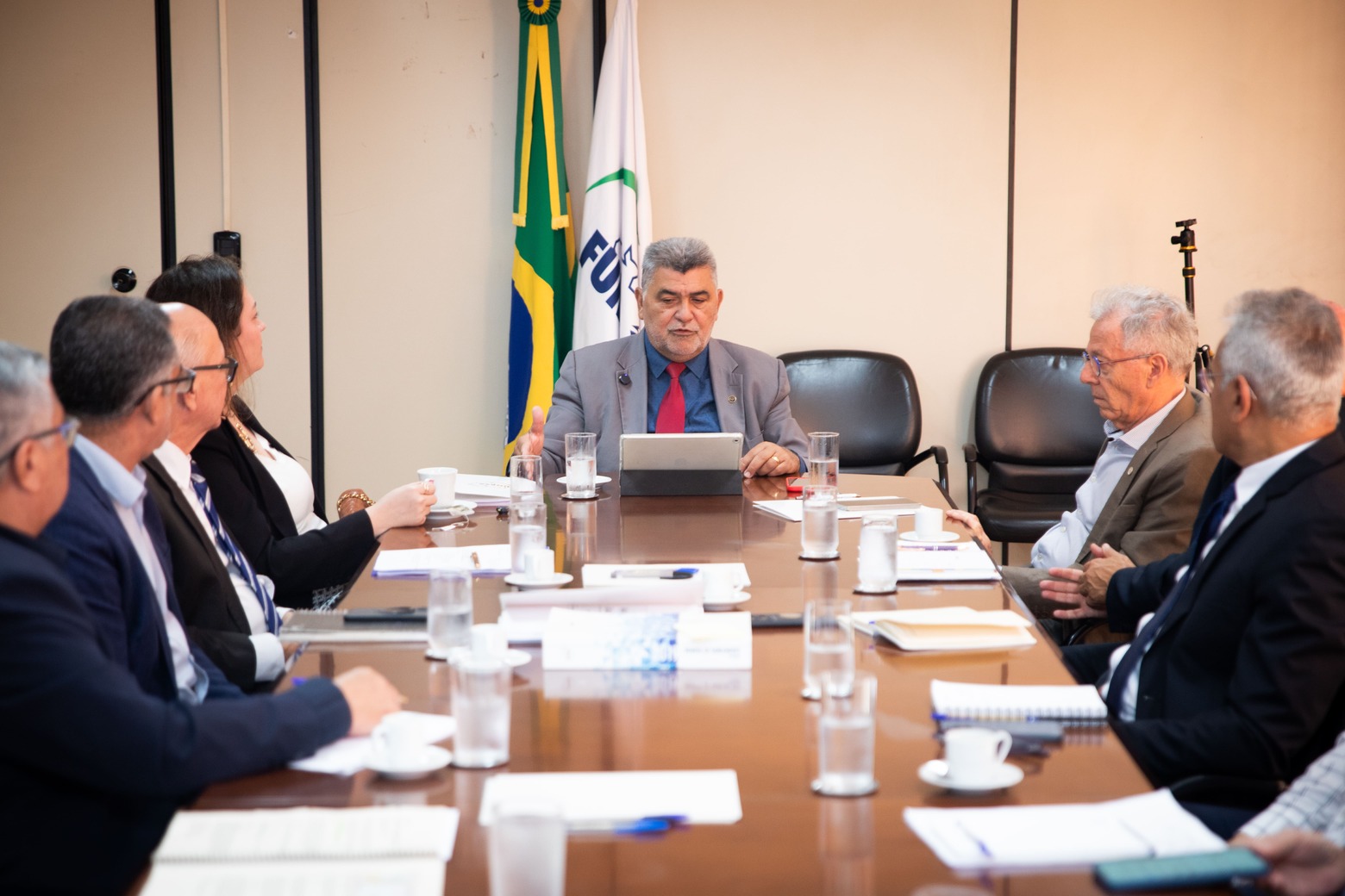 Presidente da Funasa discursa na cabeceira de mesa durante reunião de alinhamento.