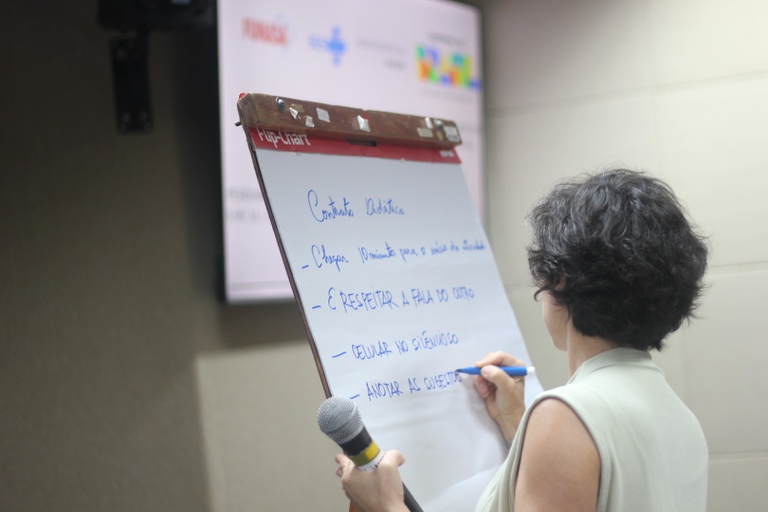 Registro de servidores atentos durante a explicação sobre a metodologia de transmissão de informações para famílias beneficiadas.