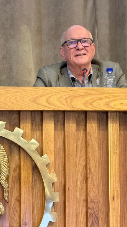 José Antonio fala ao microfone em púlpito lateral durante o evento, destacando a importância do saneamento rural.