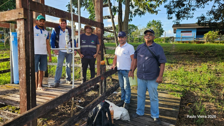 Grupo de técnicos realiza vistoria em unidade do Salta-Z feita de madeira escura, localizada em campo gramado próximo a uma construção.