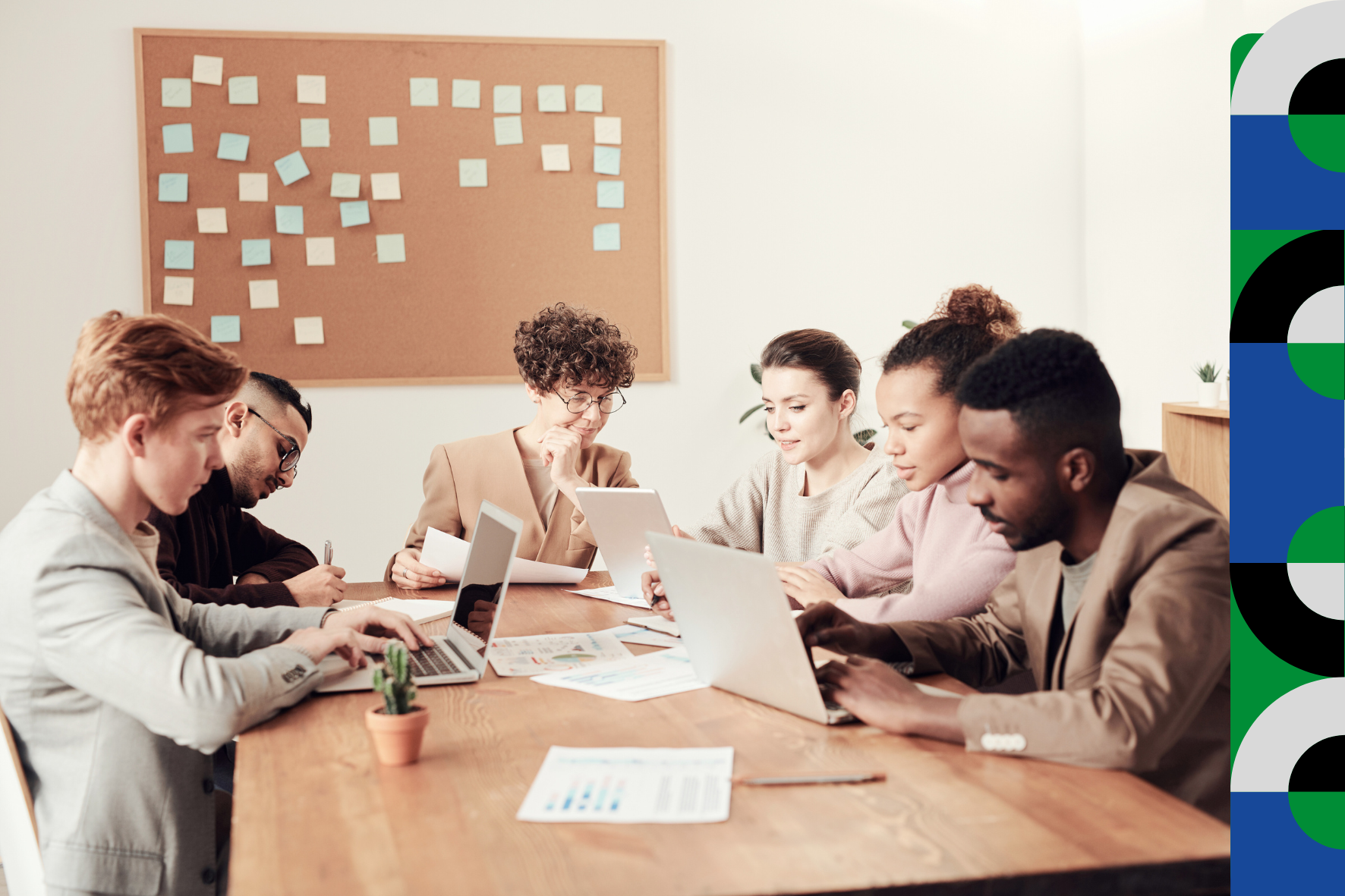 Seis pessoas trabalham com computadores e documentos em uma mesa única