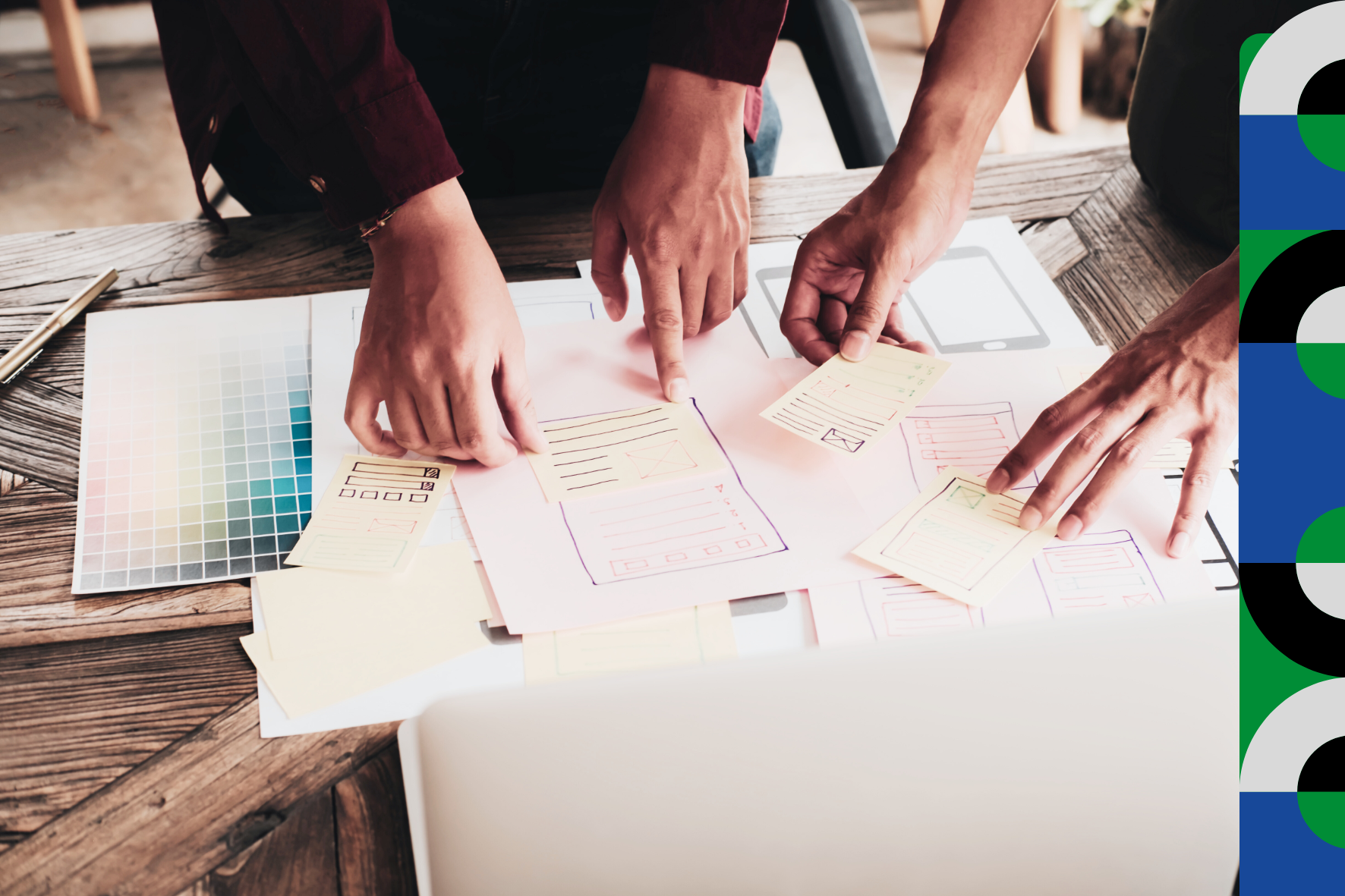 Foto com mãos de duas pessoas que estão trabalhando em uma mesa com uma série de documentos de trabalho