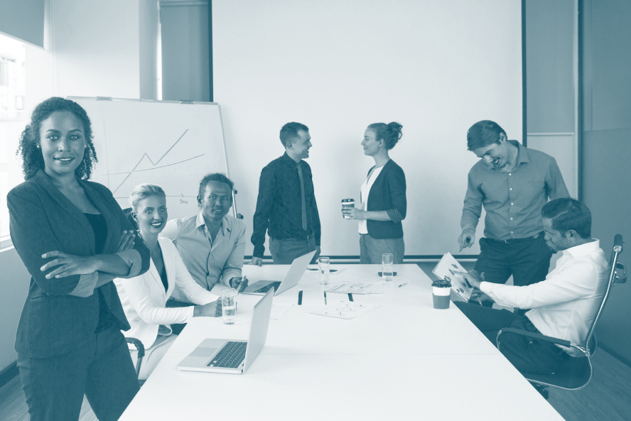Equipe de TIC ao redor de uma mesa com destaque em primeiro plano para uma mulher