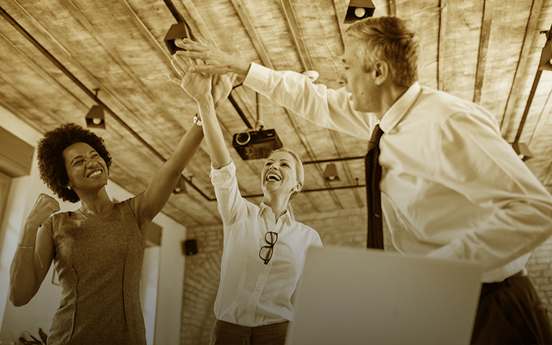 Duas mulheres e um homem com as mãos esticadas cumprimentando-se.