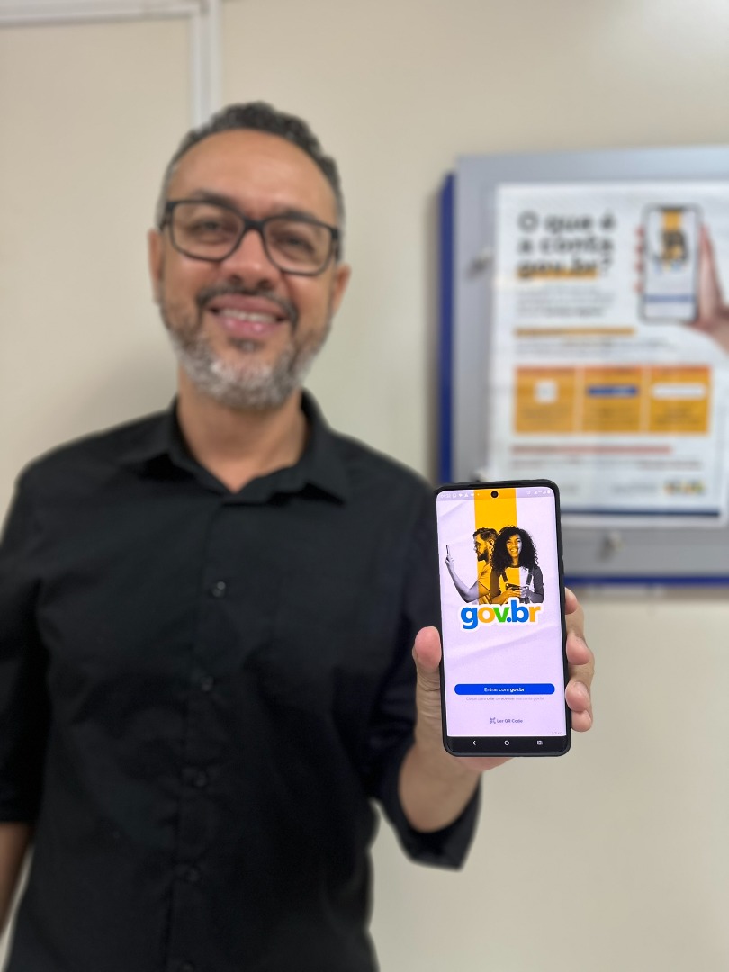 Cidadão com celular na mão mostrando o aplicativo gov.br.