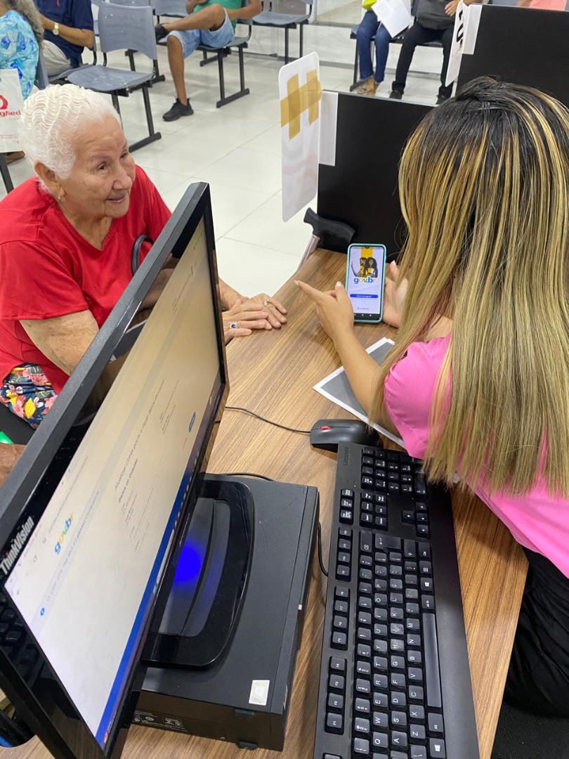 Cidadãos recebendo suporte nos Espaços da Cidadania do Piauí, com atendentes orientando diretamente nos guichês.