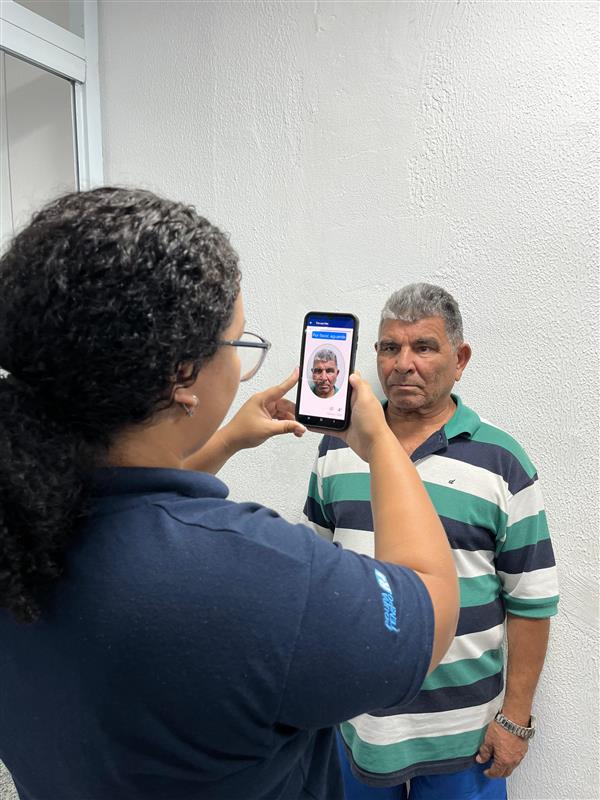 Servidores do Poupa Tempo do Rio de Janeiro atendendo moradores em balcões, com pessoas aguardando e recebendo suporte presencial.