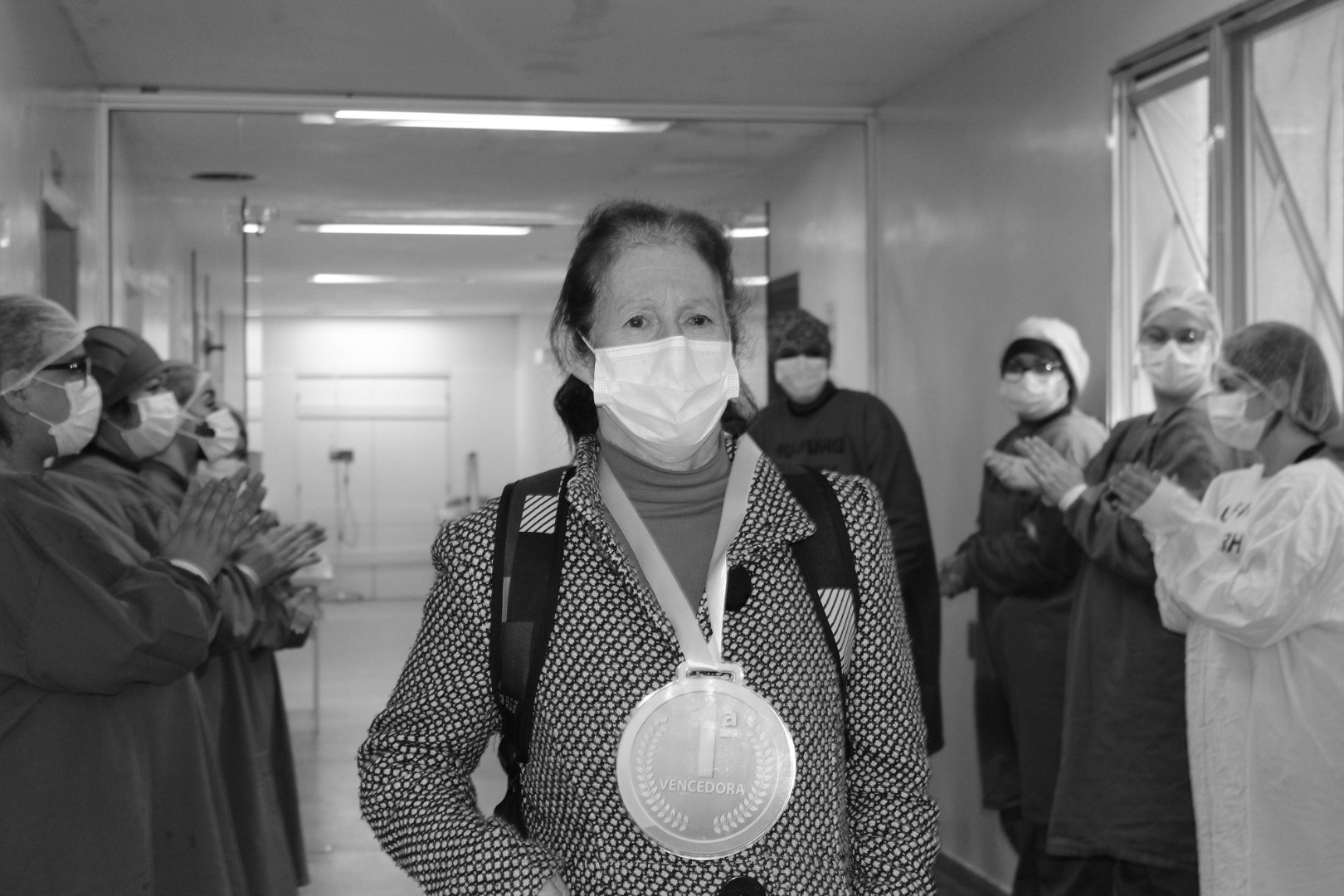 Primeira paciente recuperada de Covid-19 do HU-Furg, com sua medalha de vencedora, sendo aplaudida pelos profissionais da Área Covid-19 - Foto: Mariana Lucas