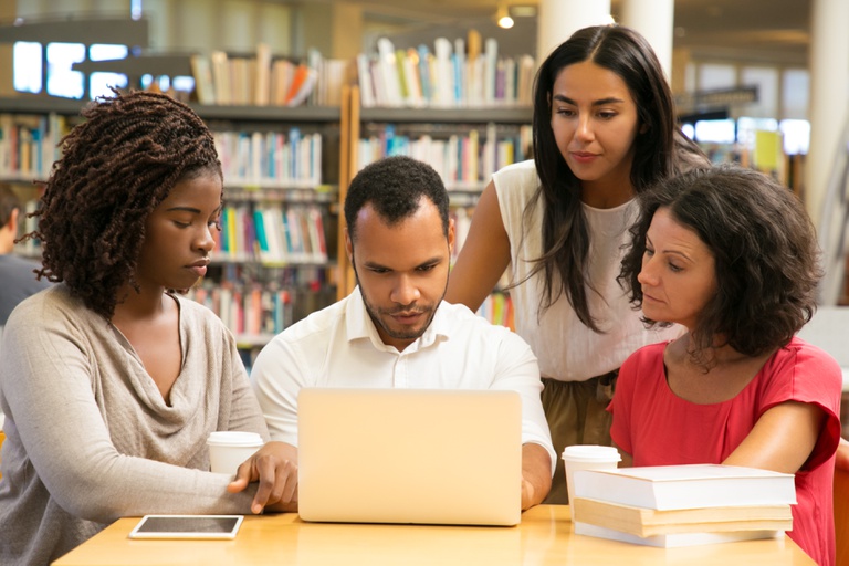 grave-estudantes-maduros-trabalhando-com-laptop-na-biblioteca-publica.jpg