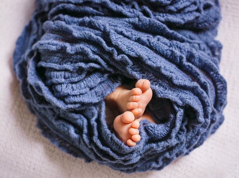 pes-de-bebe-recem-nascido-envolvido-em-lenco-azul_8353-849.jpg