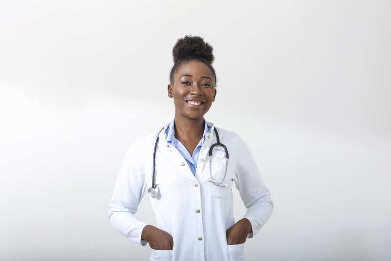 medico-com-uma-mao-de-estetoscopio-no-bolso-close-de-uma-mulher-sorrindo-em-pe-em-linha-reta-no-fundo-branco.jpg