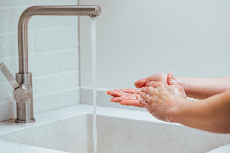 closeup-woman-rubbing-hands-with-soap-bathroom-sink.jpg