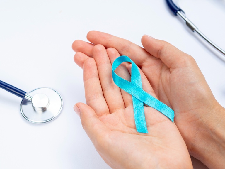 close-up-hands-holding-blue-ribbon-with-stethoscope.jpg