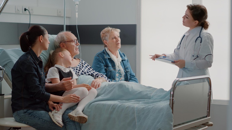 medico-explicando-o-diagnostico-ao-paciente-idoso-e-a-familia-em-visita-sentado-na-cama-da-enfermaria-do-hospital-homem-senior-falando-com-clinico-geral-sobre-tratamento-e-medicina-tendo-pessoas-visitando.jpg