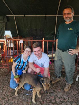 Foto de um casal feliz após adotar um cachorro