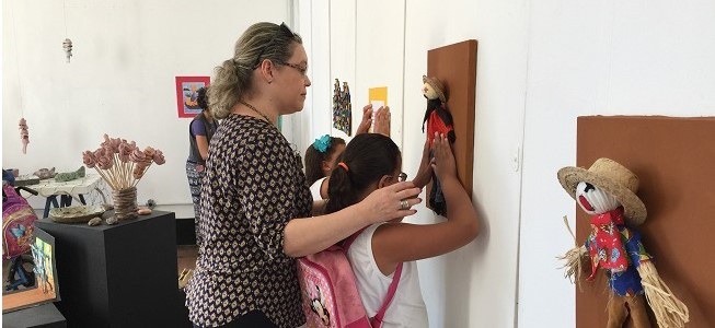 Aluna faz exploração tátil com ajuda da professora