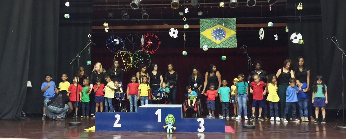 Foto de crianças e professores no palco do teatro do IBC