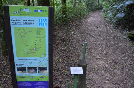 Entrada da trilha Caminho Dom Pedro Augusto. Trilha adaptada com corredor amplo, solo nivelado, corrimões e placas interpretativas em braile no Parque Nacional da Tijuca