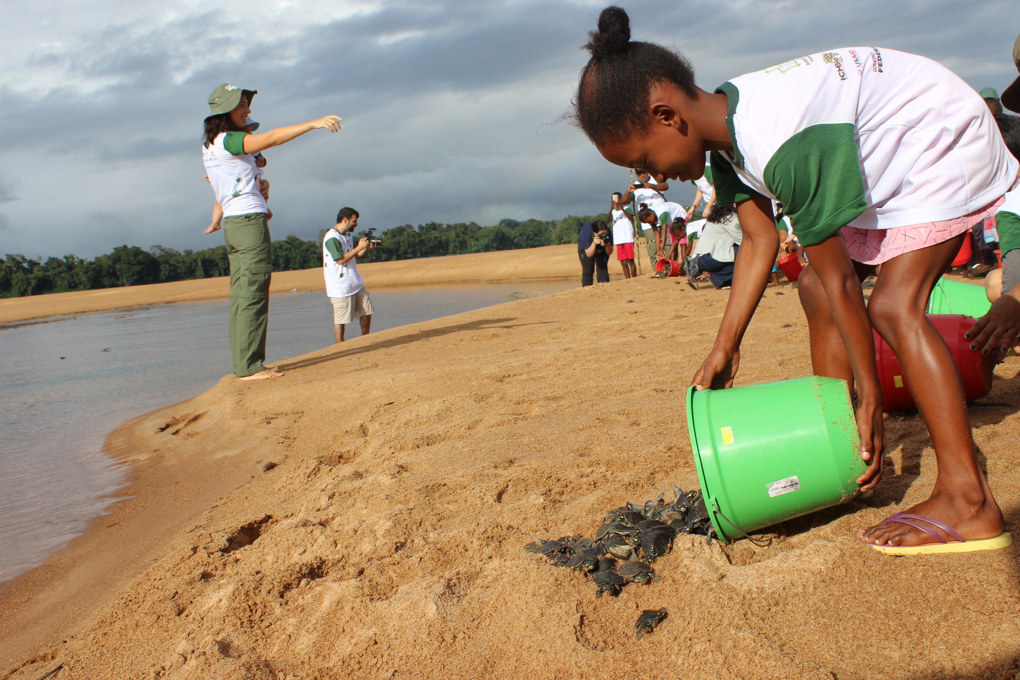  Criança ajuda na soltura das pequenas tartarugas (Foto: Ramilla Rodrigues)   