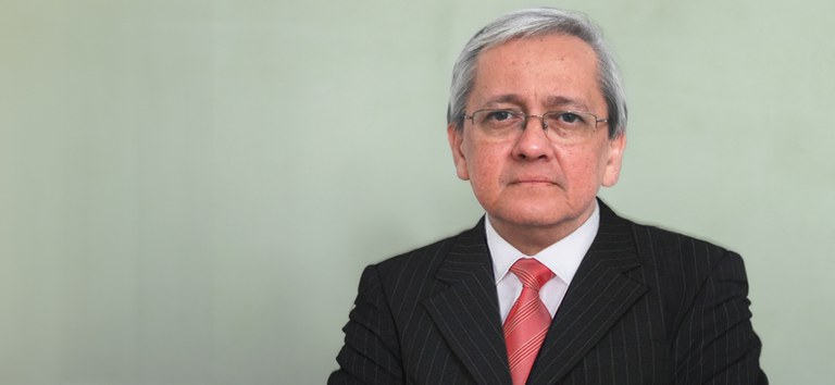 Imagem do pesquisador, sério, ao lado direito