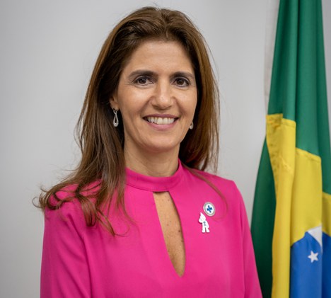 Imagem de mulher sorrindo com a bandeira do brasil ao fundo