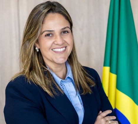 Imagem de mulher sorrindo com a bandeira do brasil ao fundo