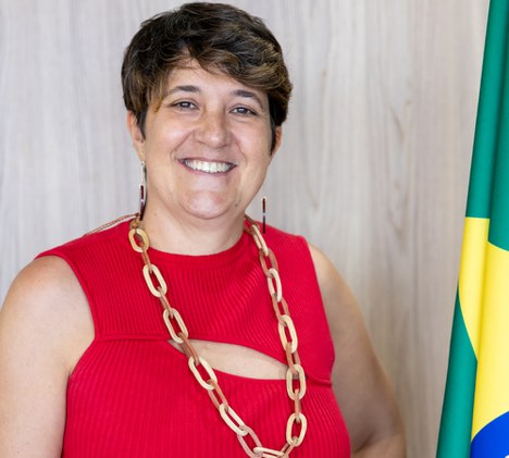 Imagem de mulher sorrindo com a bandeira do brasil ao fundo