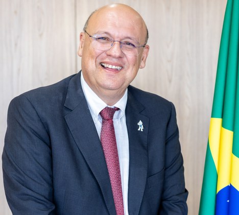 Imagem de homem branco sorrindo com a bandeira do Brasil ao fundo