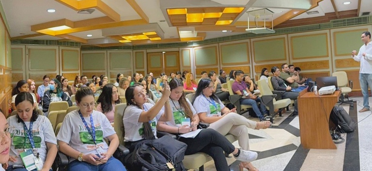 Pessoas assistindo um palestrante branco durante o evento