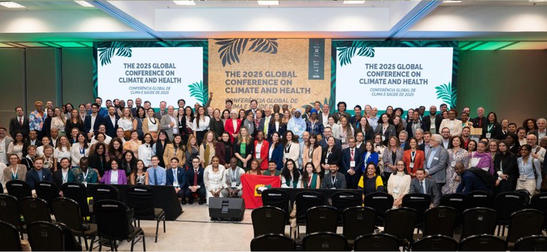 Palco com dois telões laterais e um grupo grande de pessoas na frente.