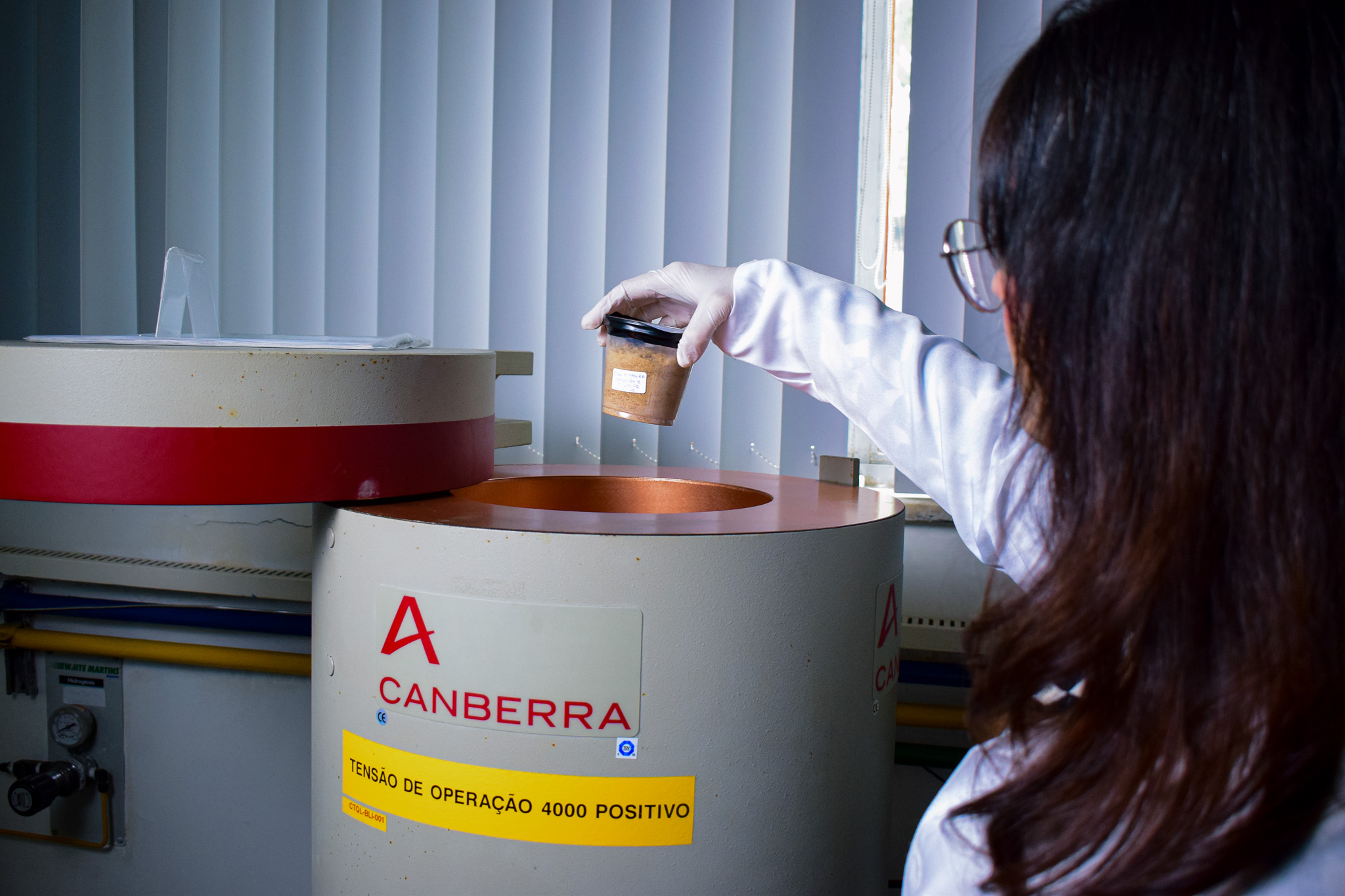 Caroline Reis colocando uma das amostras de farinha de banana em detector de espectometria gama