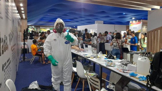 Servidor da CNEN vestindo a roupa tyvek na SBPC