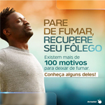 Homem negro, de camiseta branca, respirando profundamente, sob fundo degradê de marrom para azul. À direita, os dizeres: "Pare de fumar, recupere seu fôlego. Existem mais de 100 motivos para deixar de fumar. Conheça alguns deles!".