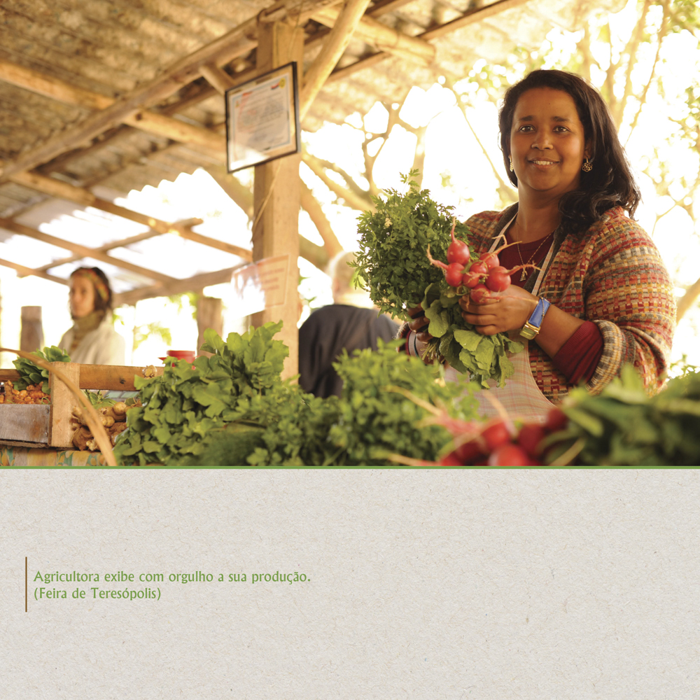 Agricultora exibe com orgulho a sua produção de rabanete e outras folhagens.