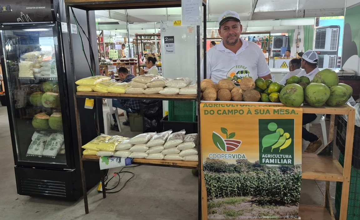 Homem em uma banca de feira com produtos da agricultura familiar