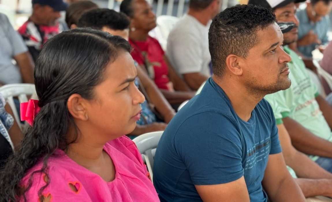 Visão lateral de uma mulher e um homem sentados olhando para a frente.