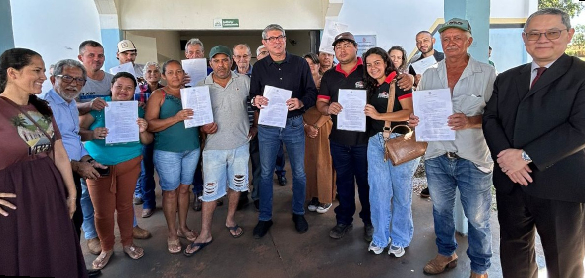 Um grupo de pessoas, incluindo homens e mulheres, posa para uma foto segurando documentos.