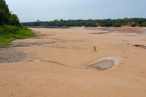 Ribeirinho andando pelo lago seco em 2023. Foto: Miguel Monteiro-  Instituto Mamirauá.  