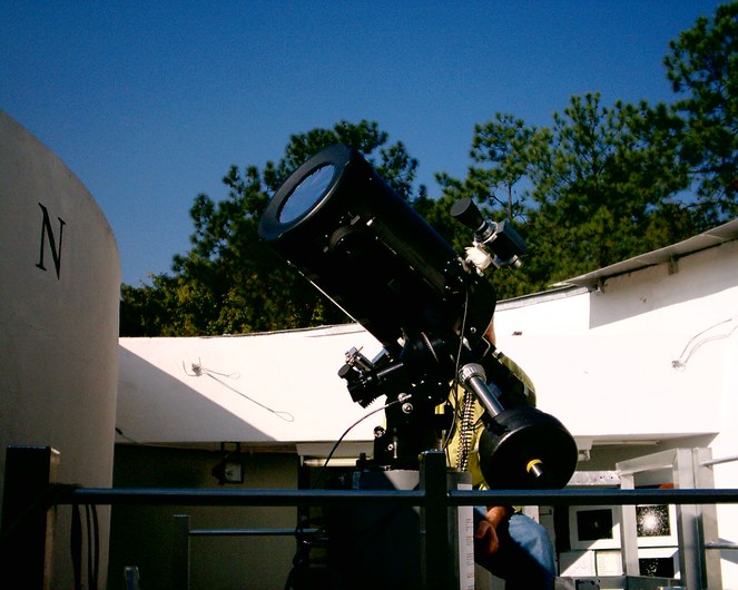 Telescópio, prédio com teto aberto.