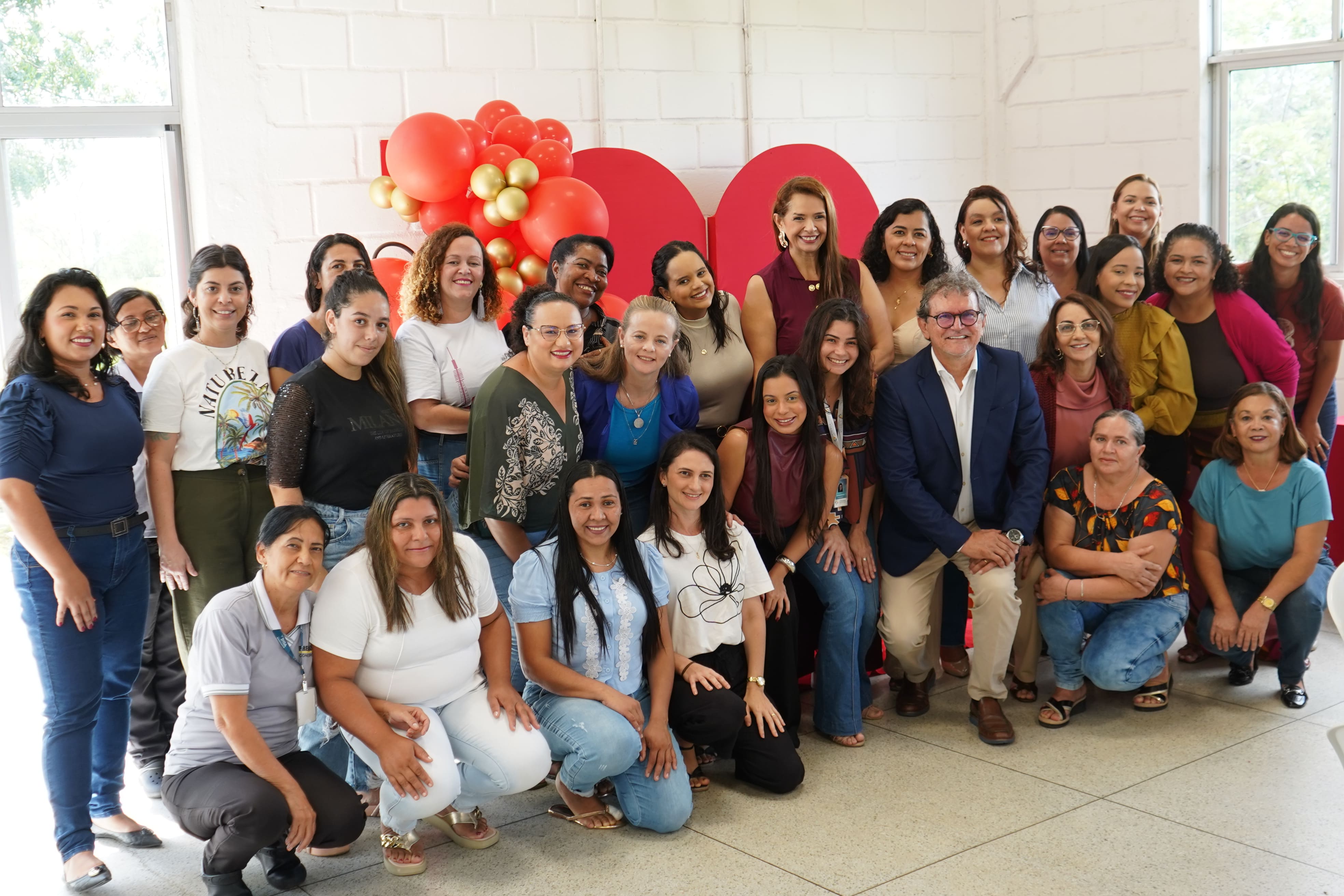 Mulheres, trabalhadoras do INSA reunidas na foto, diretor no meio.