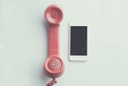Telefone rosa a esquerda e celular branco a direita