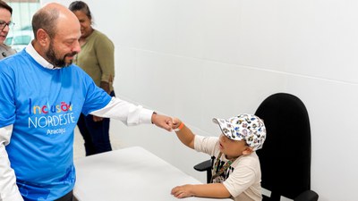 Presidente do INSS, Gilberto Waller Júnior, cumprimenta criança atendida em ação do projeto em Aracaju (SE)