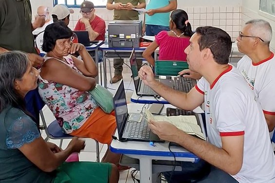 Descrição da imagem: Hariwaque Karajá recebe atendimento de servidores do INSS, durante a segunda edição do projeto Defensorias do Araguaia. Foto: Secom/MT INSS.