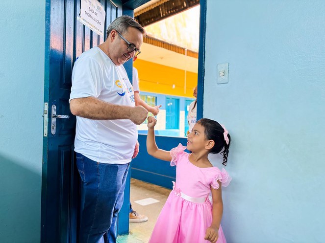 Superintendente regional interagindo com criança atendida na ação em Porto Velho (RO). Foto: Roneymar Alves